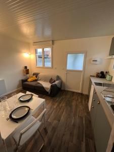 ベグルにあるLa Bordelaise - Logement cosy avec jardin à Bèglesのソファとテーブルのある小さなリビングルーム