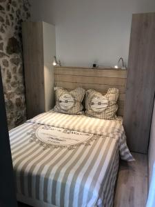 uma cama com um cobertor listrado e almofadas em Vieil Antibes, ravissant 2p avec petite terrasse em Antibes