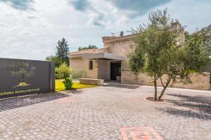 un edificio con un árbol delante de él en My Mediterranean Corfu Luxury Villa with Private Swimming Pool, en Kontokali