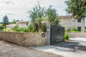 una puerta en una pared de piedra junto a una casa en My Mediterranean Corfu Luxury Villa with Private Swimming Pool en Kontokali