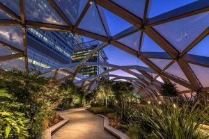 a large glass building with a pathway in a garden at Hi-End 2BR, 2BR Apt, Heart of Canary Wharf in London