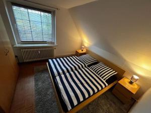 a bedroom with a bed with striped pillows and a window at Schöne Wohnung an der Nordsee in Mildstedt in Mildstedt