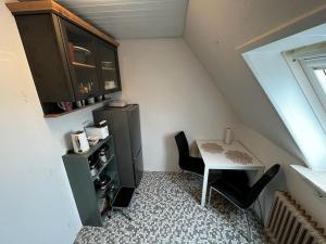 Cette petite chambre comprend une petite table, une table et des chaises. dans l'établissement Schöne Wohnung an der Nordsee in Mildstedt, à Mildstedt