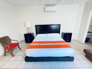 - une chambre avec un grand lit et une chaise dans l'établissement Casa cerca del mar! 4 Habitaciones con aire acondicionado, à Puerto Vallarta