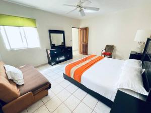 una camera con un grande letto e un divano di Casa cerca del mar! 4 Habitaciones con aire acondicionado a Puerto Vallarta