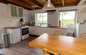 een keuken met witte apparatuur en een houten tafel bij Vakantiehuis met fraai uitzicht in Echten