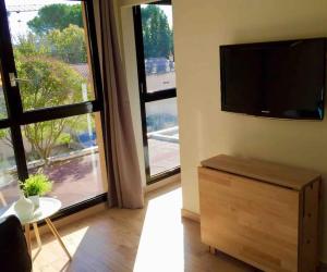 ein Wohnzimmer mit einem Flachbild-TV an der Wand in der Unterkunft Ma place au sud Aix Parking in Aix-en-Provence