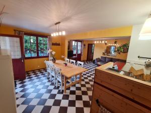 Il comprend une cuisine et un salon avec une table et des chaises. dans l'établissement Gîte de l'orangerie du château de Jallanges- 11 personnes, à Vernou-sur-Brenne