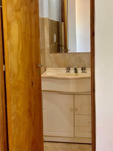 een badkamer met een wastafel en een spiegel bij El RECREO 4 in Garupá