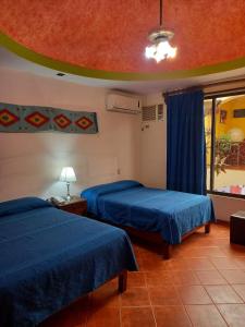 a hotel room with two beds and a window at Hotel Doña Alicia in Oaxaca City