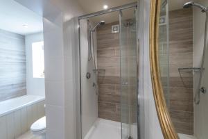 a bathroom with a shower with a glass door at The Dial House in Bourton on the Water