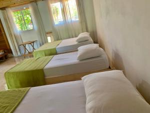 drie bedden in een kamer met een kamer met tweederde sessies bij El RECREO 4 in Garupá