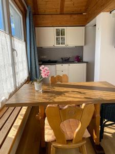 uma cozinha com uma mesa de madeira com cadeiras e um estofados de esteira em Landhaus & Pension Christian em Füssen