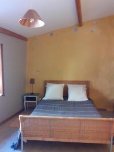 Cette chambre comprend un lit avec des draps bleus et un mur jaune. dans l'établissement Gite de Pascal et Virginie, à Ponet-et-Saint-Auban