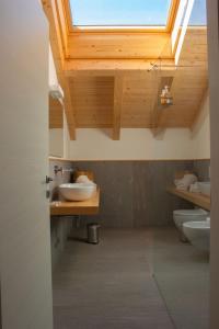 ein Badezimmer mit zwei Waschbecken und einem Dachfenster in der Unterkunft B&B Villa Cavallier in Barzio