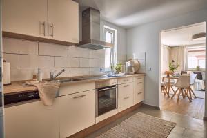 a kitchen with white appliances and a dining room at Cosima, mit Liebe zum Stil. in Kaiserslautern