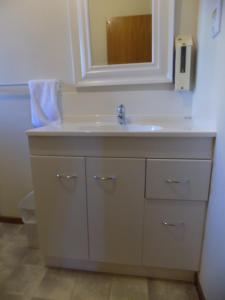 a bathroom with a sink and a mirror at Garden City Motel in Christchurch