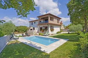 a house with a swimming pool in the yard at Villa Tina in Pinezići (Haus für 10 Personen) in Marčana