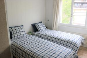 two beds sitting next to a window in a room at 2 Bedroom Apartment, ski-in/ski-out in Les Crosets in Les Crosets