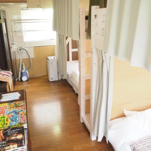 een kamer met 2 stapelbedden en een houten vloer bij Tokushima GuestHouse【uchincu】 in Tokushima