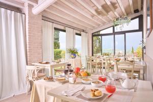 un comedor con mesas, sillas y ventanas en Il Poggio, en Celle sul Rigo