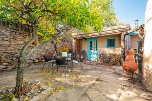 a patio with chairs and a tree in front of a building at Besos on Canyon Road in Santa Fe