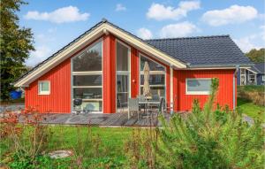 a red cottage with a deck and a table at Cozy Home In Krems Ii-warderbrck With Kitchen in Göls