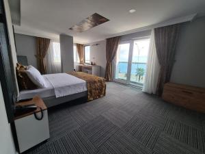サムスンにあるçepnis hotelのベッドと大きな窓が備わるホテルルームです。