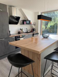 a kitchen with a wooden counter and two bar stools at Appartements BERGTRAUM in Gröbming