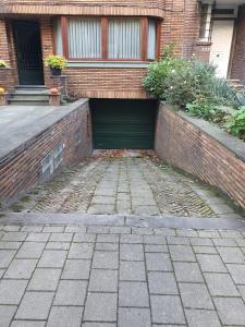 a brick building with a garage in front of it at Bel appartement avec vue sur parc - Tour Japonaise in Brussels