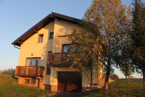 ein Haus mit einem Balkon und einem Baum in der Unterkunft Rooms & Apartment Vinia in Bjelovar
