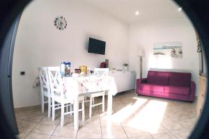 sala de estar con mesa y sofá púrpura en Chiara's Home, en Brindisi