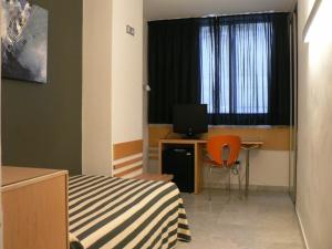 a bedroom with a bed and a desk with a computer at Hotel Nautico in Santa Cruz de Tenerife