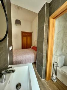 łazienka z umywalką oraz sypialnia z łóżkiem w obiekcie Pasaje San Fernando w Alicante