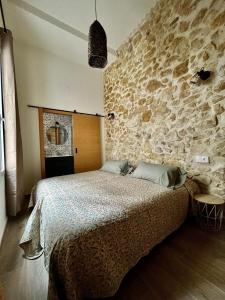 sypialnia z dużym łóżkiem i kamienną ścianą w obiekcie Casa del Pasaje San Fernando w Alicante
