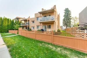 una cerca frente a una casa con un patio en Grandma's Elephant Hideaway, en Penticton