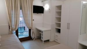 1 dormitorio con muebles blancos y ventana en New Hotel, en Lido di Jesolo