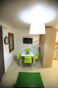 a dining room with a table and green chairs at Ca Isaak in Denia