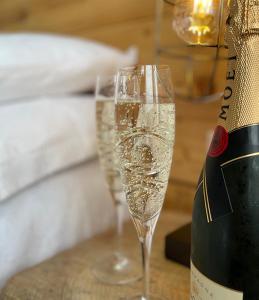 dos copas de champán en una mesa junto a una botella de champán en Môr Heli Guest House Criccieth, en Criccieth