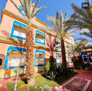 a house with palm trees in front of it at Riad Jasmine Sud in Zagora