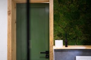 a green door with a roll of toilet paper on a counter at Panorama / TinyHouse in Podbrezová