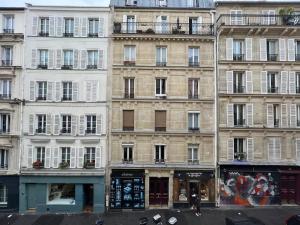 wysoki budynek przed budynkiem w obiekcie Why Paris ? Why Montmartre ? w Paryżu