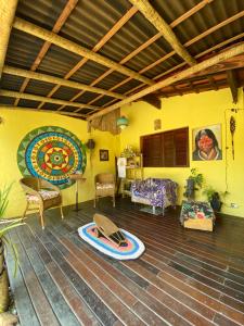 a living room with a surfboard on the floor at Casa Tribus Itamambuca in Ubatuba