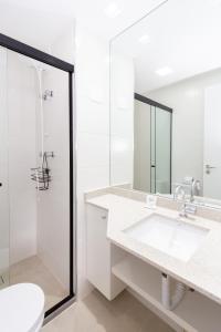 a white bathroom with a sink and a shower at 360 BW Vila Madalena in São Paulo