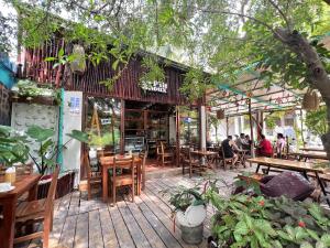 a restaurant with wooden tables and chairs and people sitting at tables at Moderno departamento cerca de la playa y la 5 Ave in Playa del Carmen