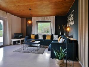 - un salon avec un canapé bleu et une table dans l'établissement Quartier12 "Ski in & Bike out" - Fewo BERG, à Willingen