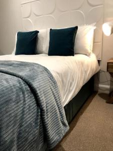 a bedroom with a large bed with blue and white pillows at Sitwell coastal apartment with free parking in Scarborough
