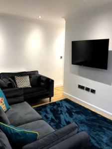 uma sala de estar com um sofá e uma televisão de ecrã plano em Sitwell coastal apartment with free parking em Scarborough