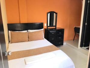 1 dormitorio con 1 cama con tocador negro y espejo en Ayenda Hotel Ecosuite Quibdó en Quibdó