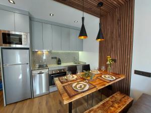 uma cozinha com uma mesa de madeira e um frigorífico de aço inoxidável em Estudio rústico en Tarter a pie de Pistas em El Tarter